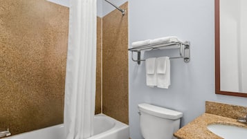 A bathroom with a bathtub, toilet, and sink.