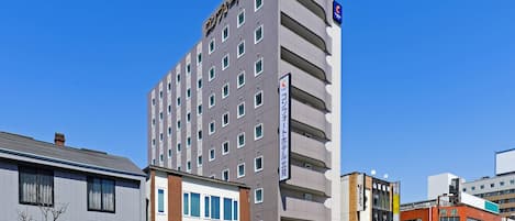 Un hotel de varios pisos con diseño moderno, que destaca un cartel en la parte superior.