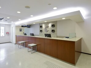 Welcome to our reception area, featuring a sleek desk and comfortable seating for guests.