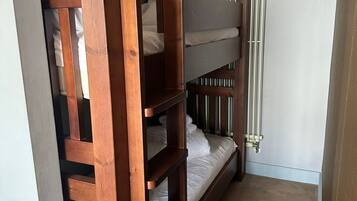 A bunk bed room with a radiator and a door frame.