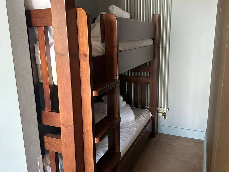 A bunk bed room with a radiator and a door frame.