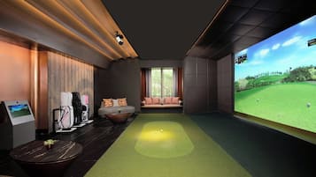A modern indoor golf simulation room with a large screen displaying a golf course, a green turf area, and a seating area with a sofa and chairs.