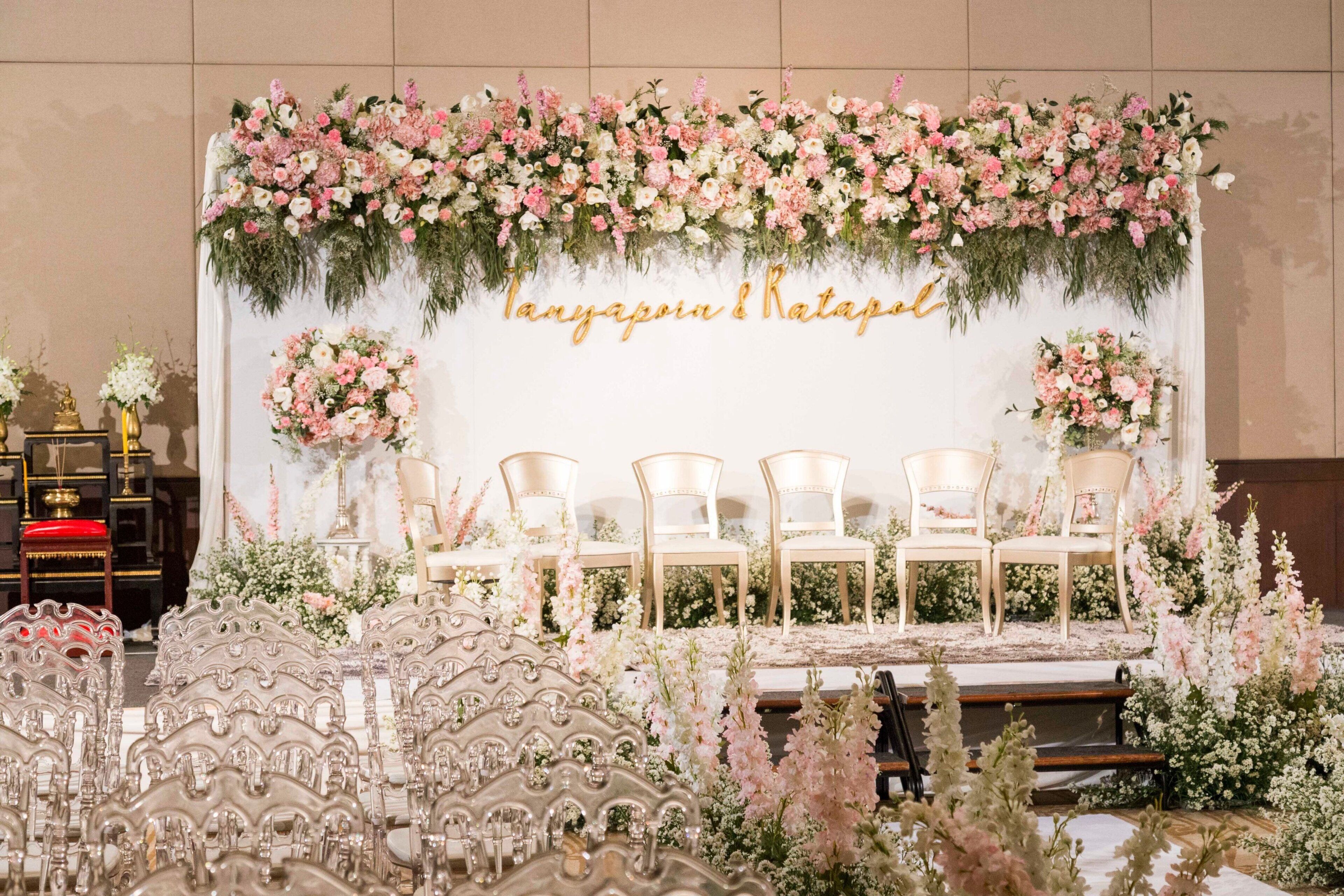 Un escenario con sillas y un fondo floral.