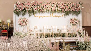 Un escenario con sillas y un fondo floral.