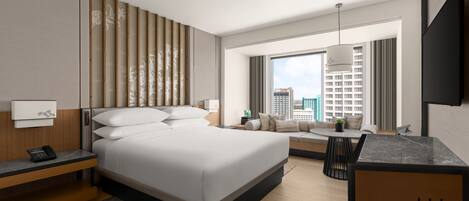A modern hotel room with a large bed, a desk, a sofa, and a city view.