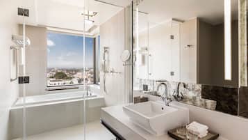 Een aparte badkuip en douche, een diep bad, een regendouche