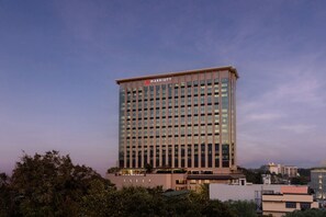 Experience the contemporary architecture of this Marriott hotel, surrounded by lush greenery and offering a pleasant view.