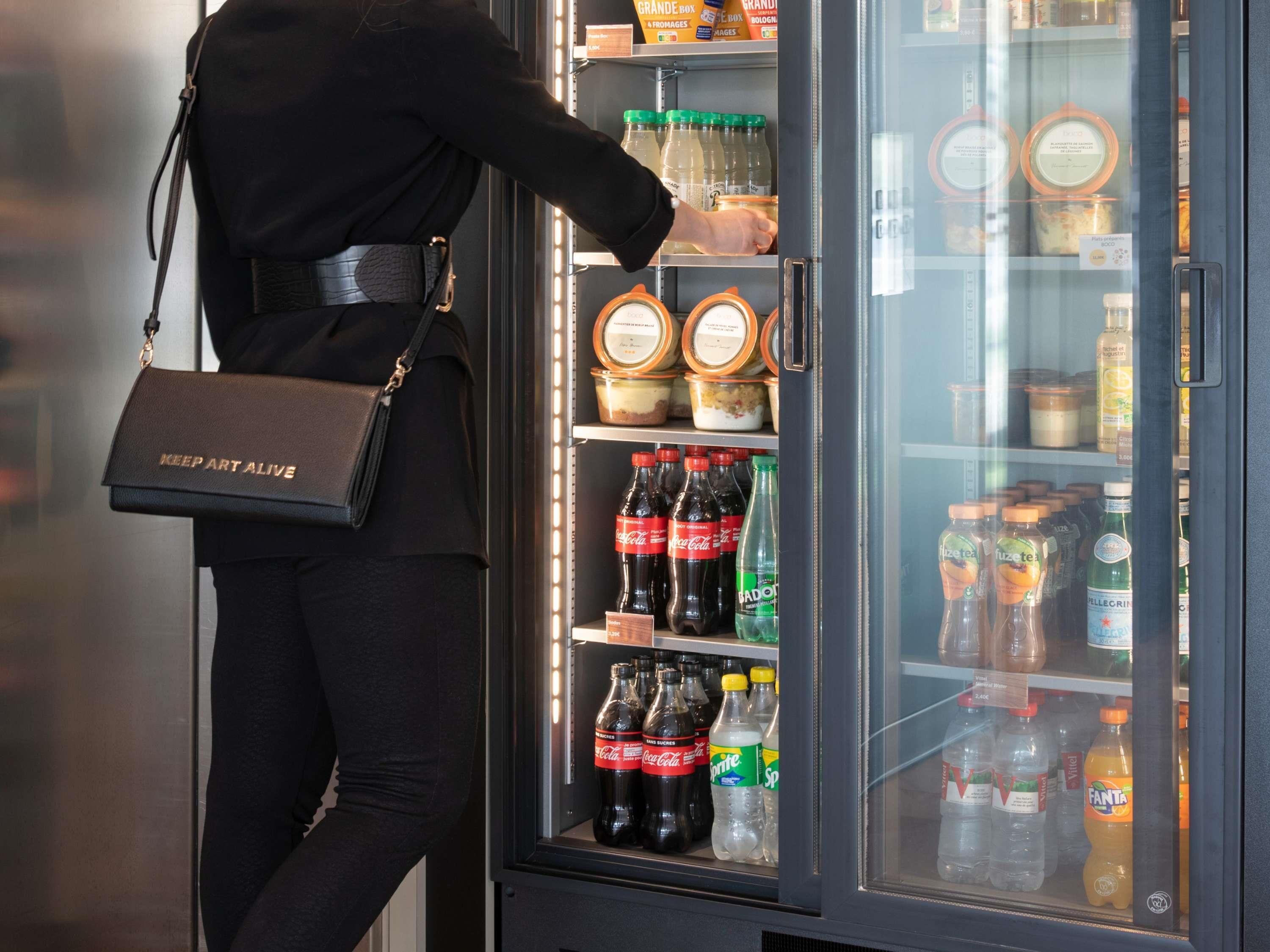 Une personne qui choisit des articles dans un mini-bar.