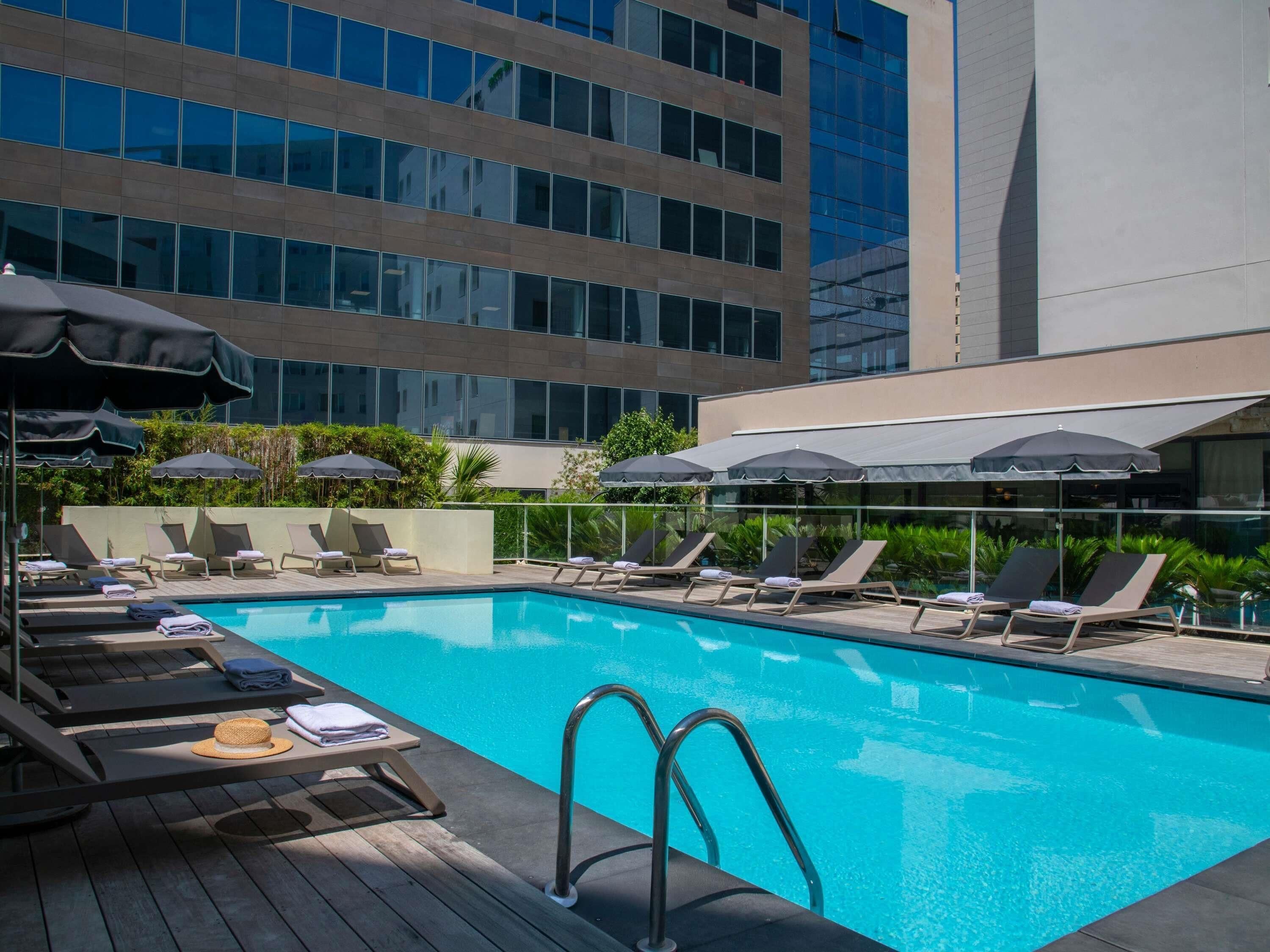 Outdoor pool, open 9:00 AM to 8:00 PM, pool umbrellas, pool loungers