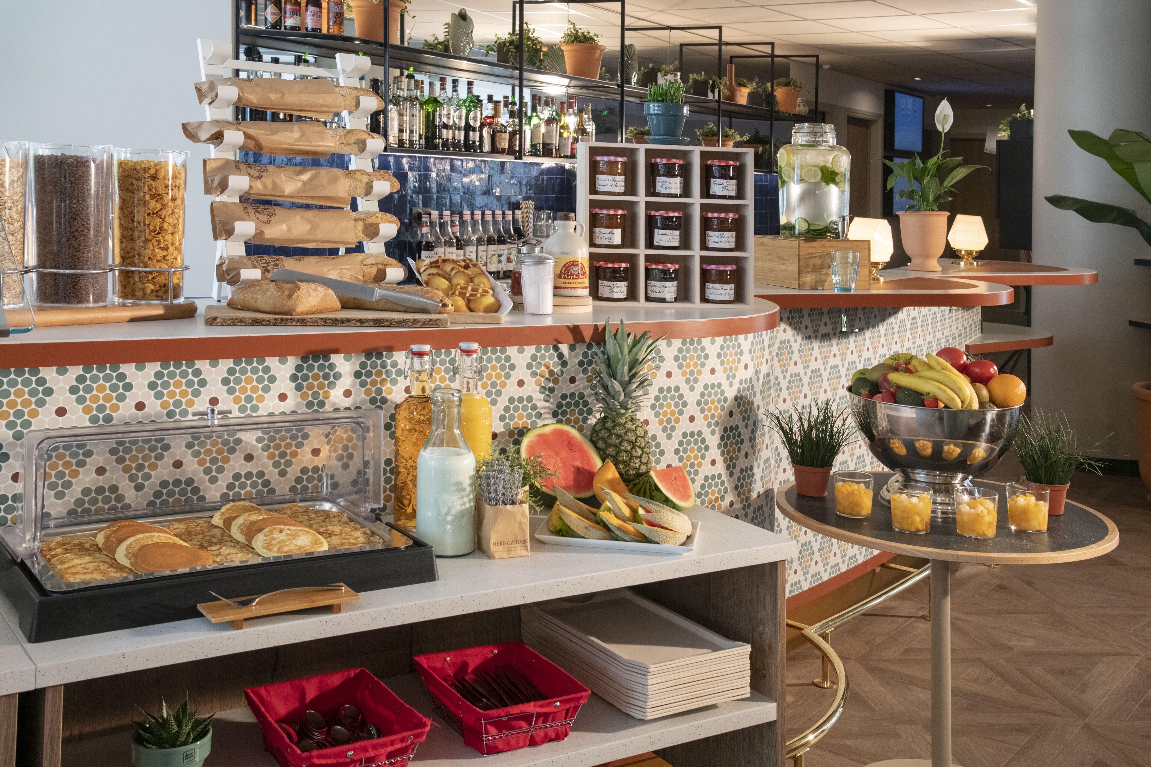 Un buffet pour le petit-déjeuner proposant divers aliments, des condiments et un saladier de fruits.