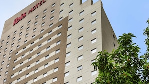 A high-rise hotel building with a modern architectural design, featuring numerous windows and a prominent signage at the top.