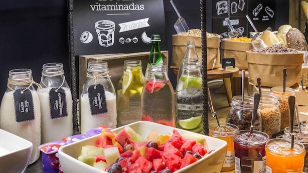 A juice bar with various fruit options and labeled bottles of milk and soy milk.