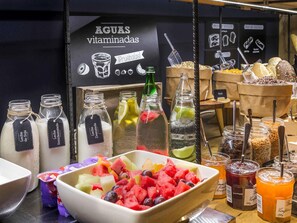 A juice bar with various fruit options and labeled bottles of milk and soy milk.