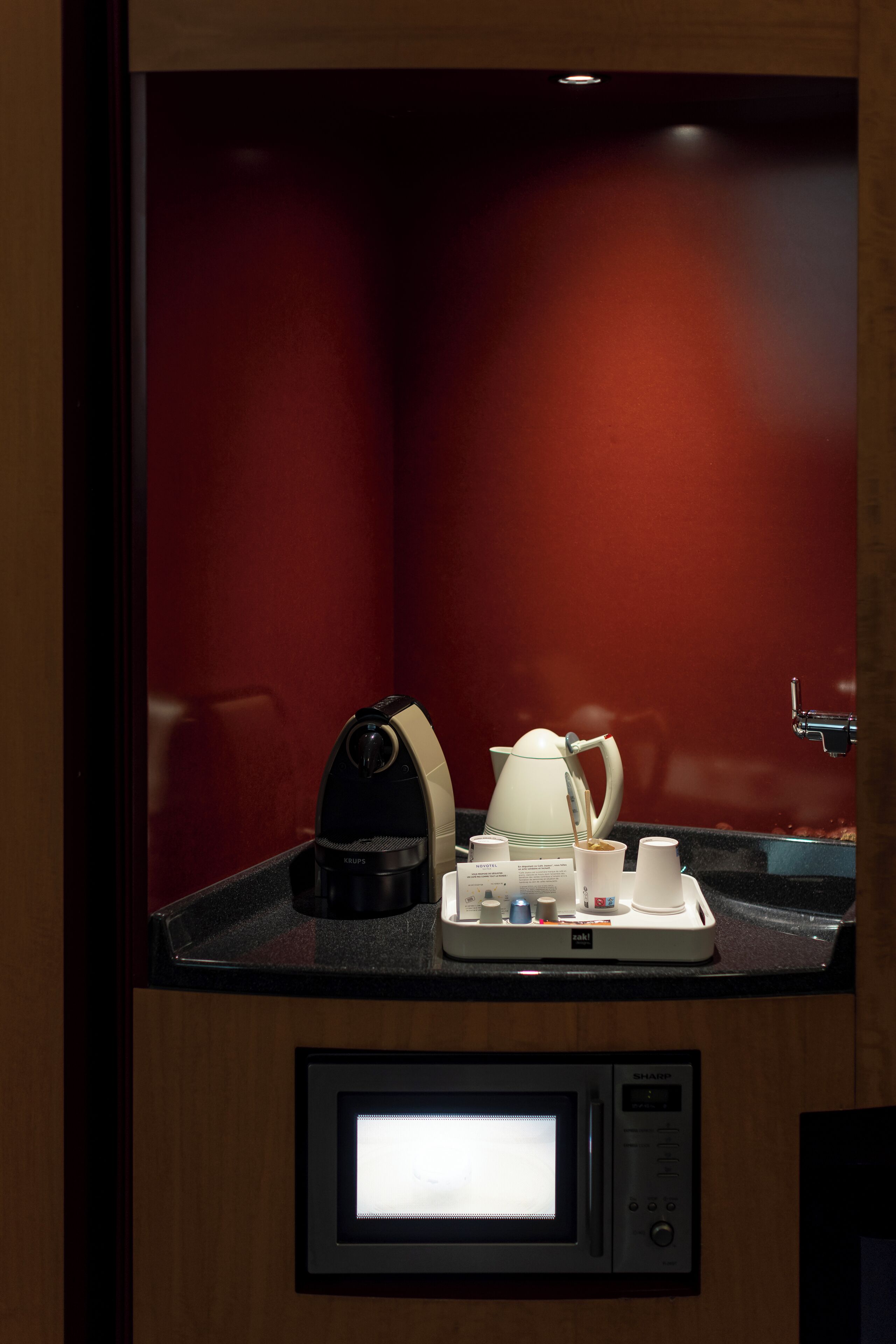 A compact kitchenette with a coffee maker, a kettle, and a microwave.