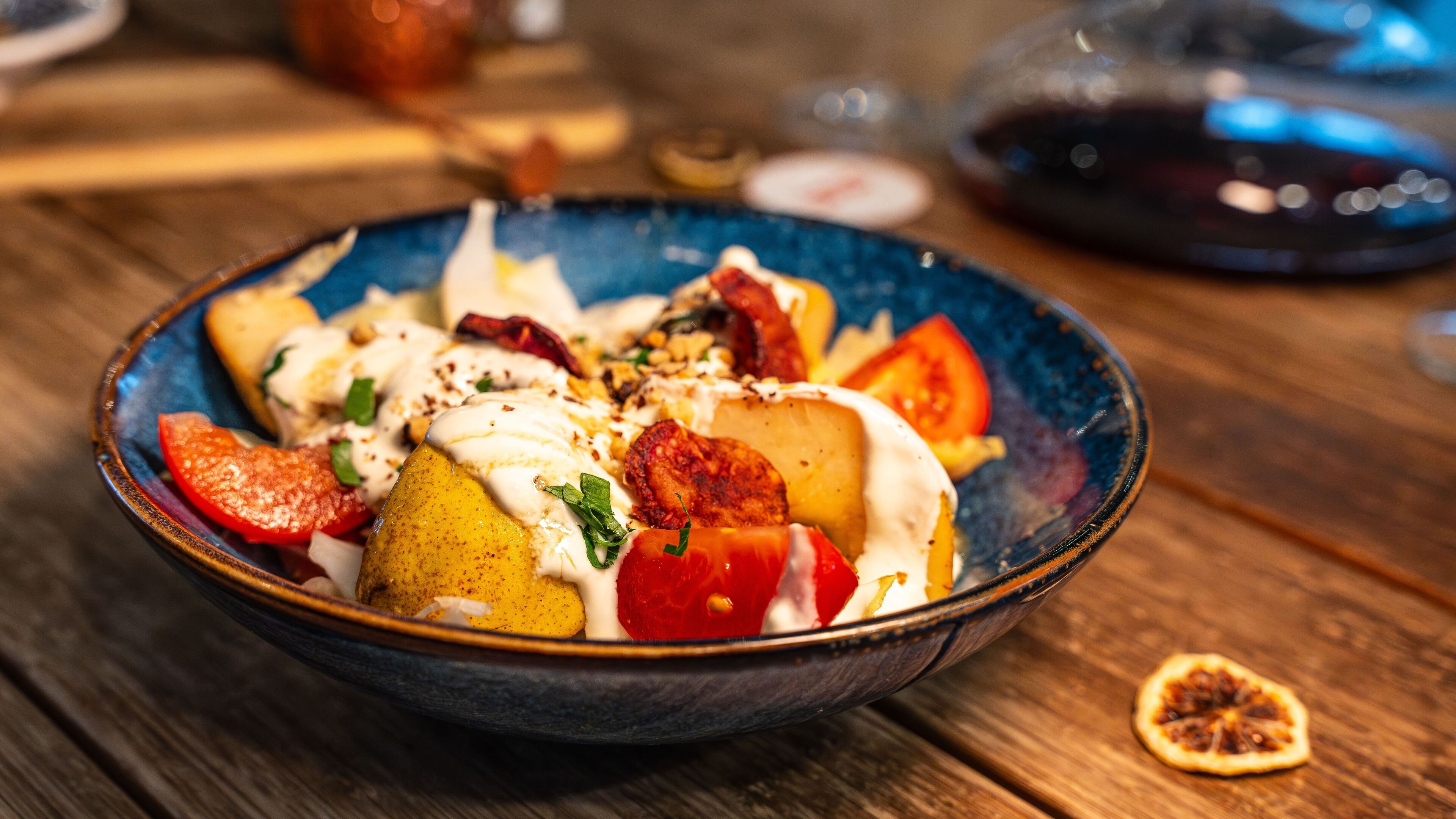 Un tazón de comida con diferentes ingredientes y una porción de fruta al lado.