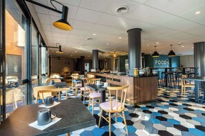 Ein modernes Café-Interieur mit hexagonalem Bodenmuster, Holztischen und -stühlen.