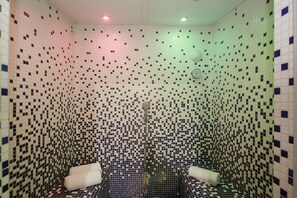 Ein Badezimmer mit Wänden aus Mosaikfliesen und einer Duschkabine.