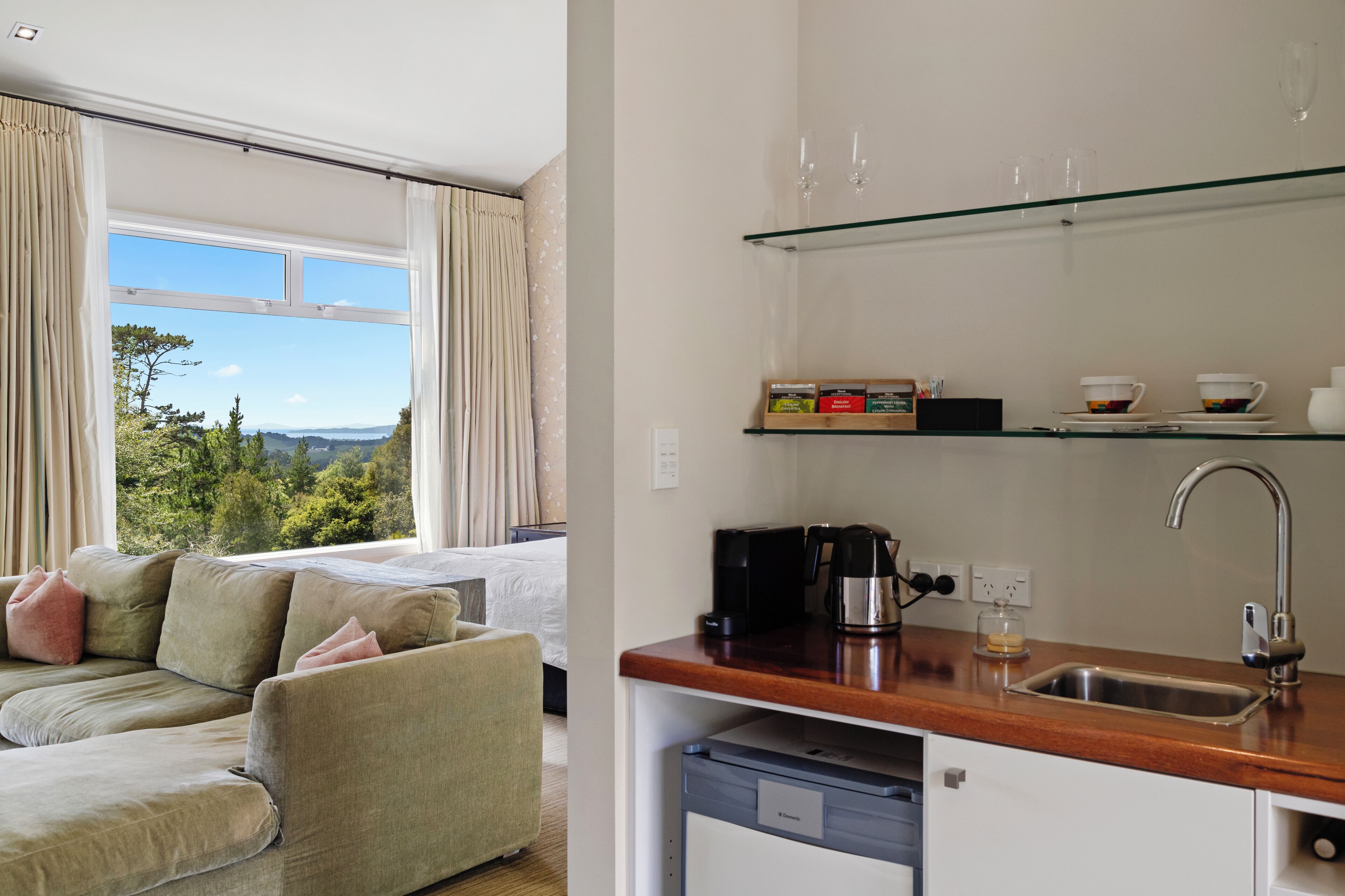A modern kitchen with a built-in dishwasher, a coffee maker, and a wine glass rack.