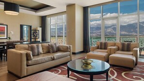 A spacious living room with a large window offering a mountain view, a dining area, and a seating area with a view. - Agua Caliente Casino Rancho Mirage (Rancho Mirage)