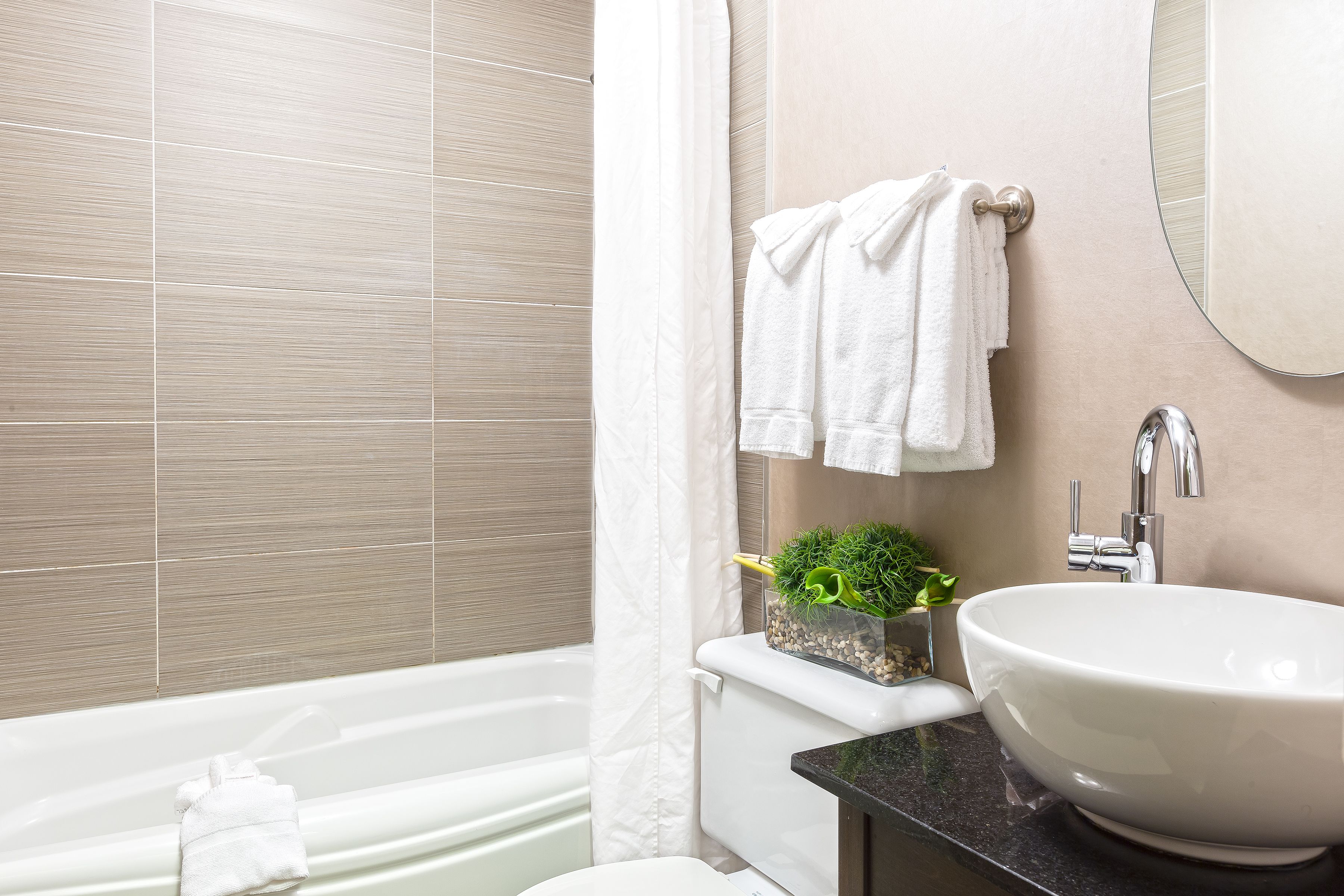 Un baño moderno con bañera, lavamanos e inodoro.