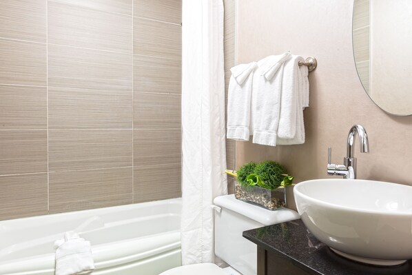 A modern bathroom with a bathtub, a sink, and a toilet.