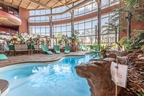 An indoor pool area with green chairs and a sign indicating a 'Pool's Platter' menu. - Hotel Universel (Québec City)