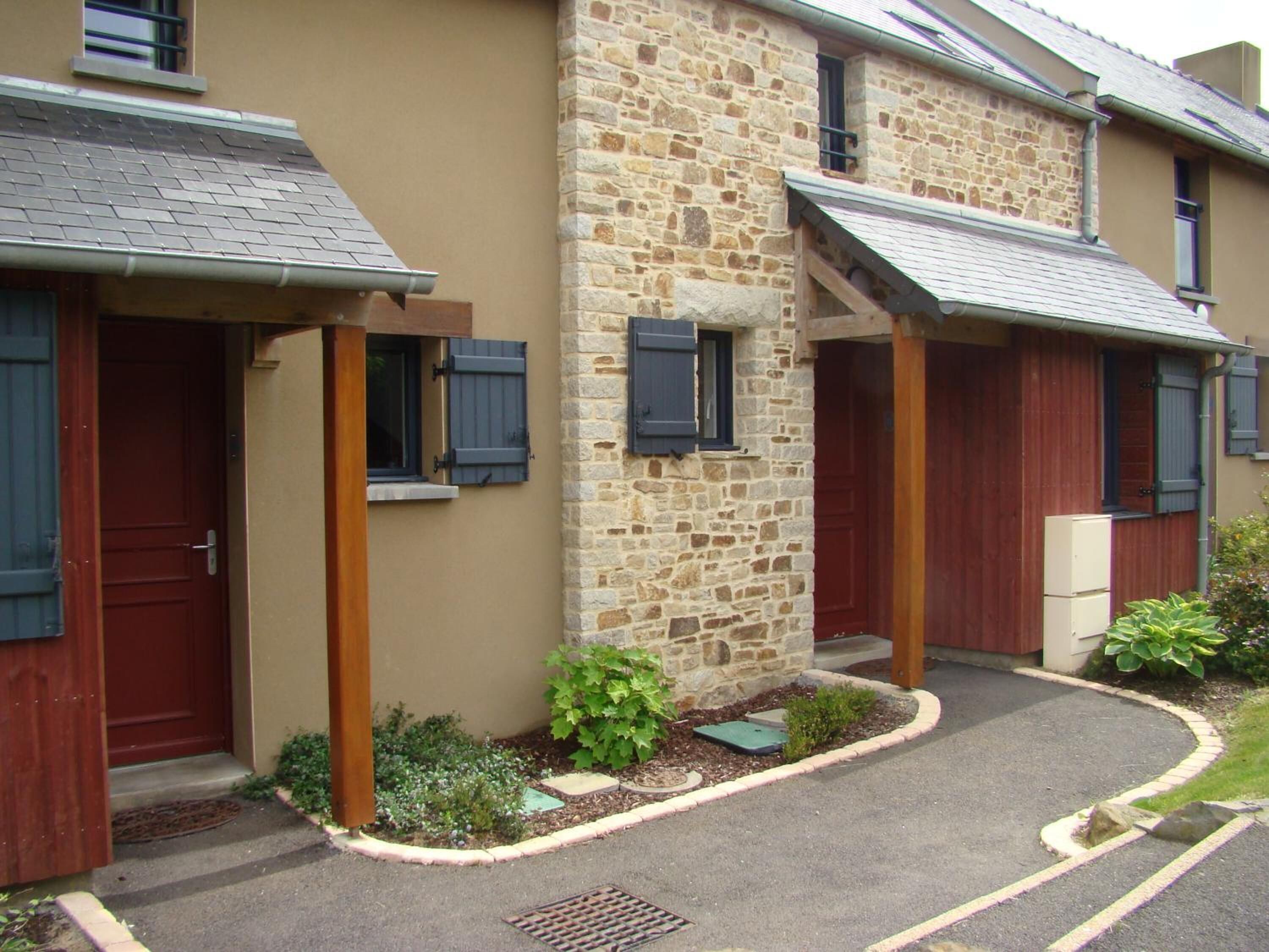 A two-story building with stone walls and wooden doors.