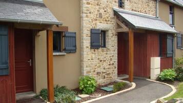 A two-story building with stone walls and wooden doors.