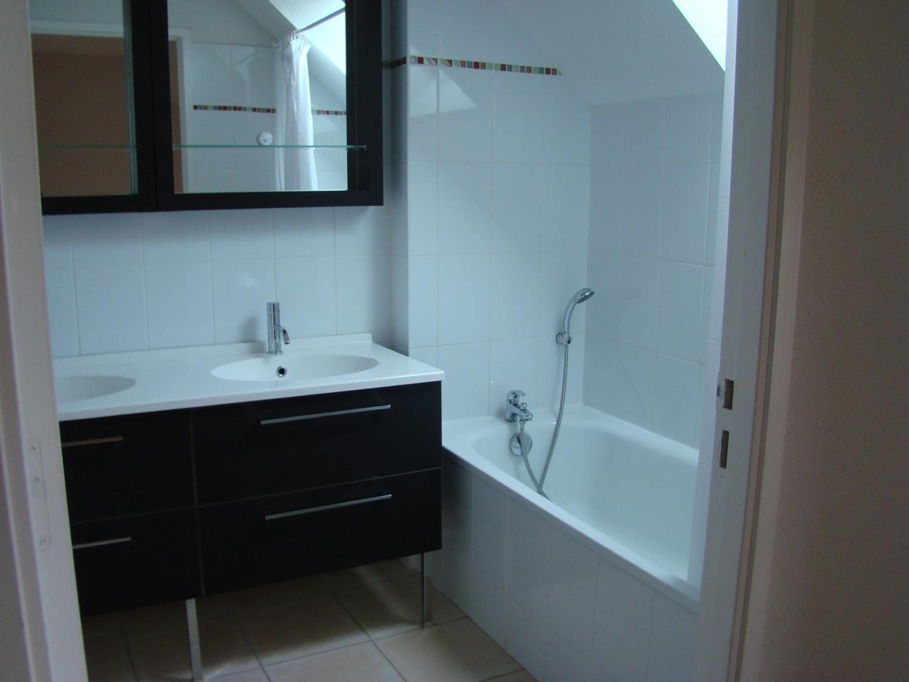 Un bagno con due lavandini, uno specchio e una vasca.