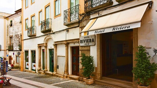 A hotel named 'Hotel Riviera' with a traditional facade, a signboard, and potted plants. - Hotel Riviera (Évora)