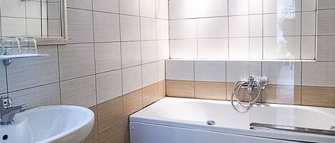 Une salle de bain avec un lavabo, des toilettes et une baignoire.