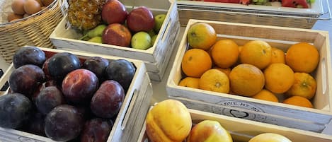 Diversa variedad de frutas y verduras expuestas en cajas y cestas de madera.