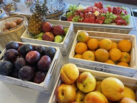 Eine Auswahl an Obst und Gemüse, präsentiert in Holzkisten und Körben.