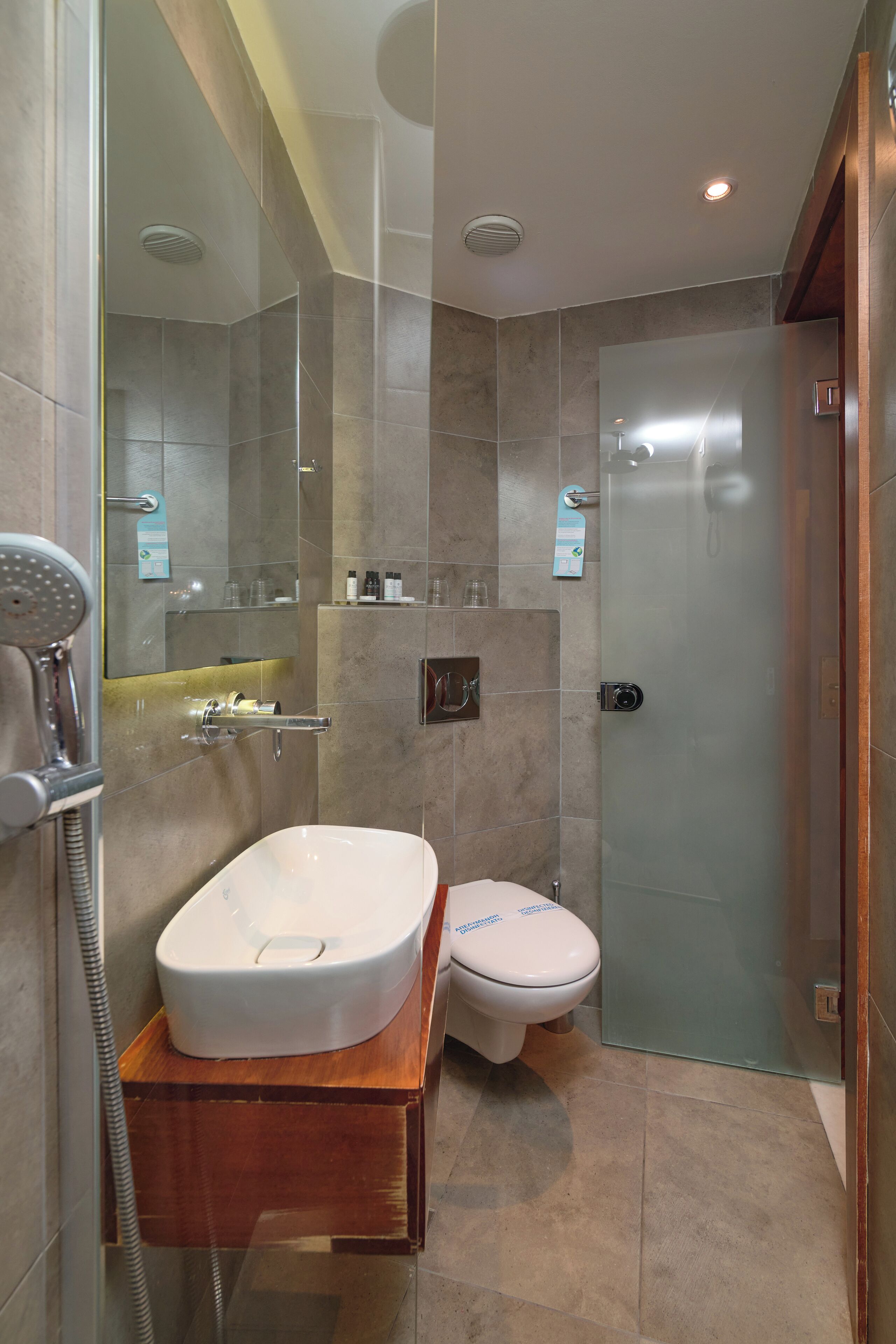 A modern bathroom with a freestanding bathtub, a toilet, and a glass-enclosed shower.