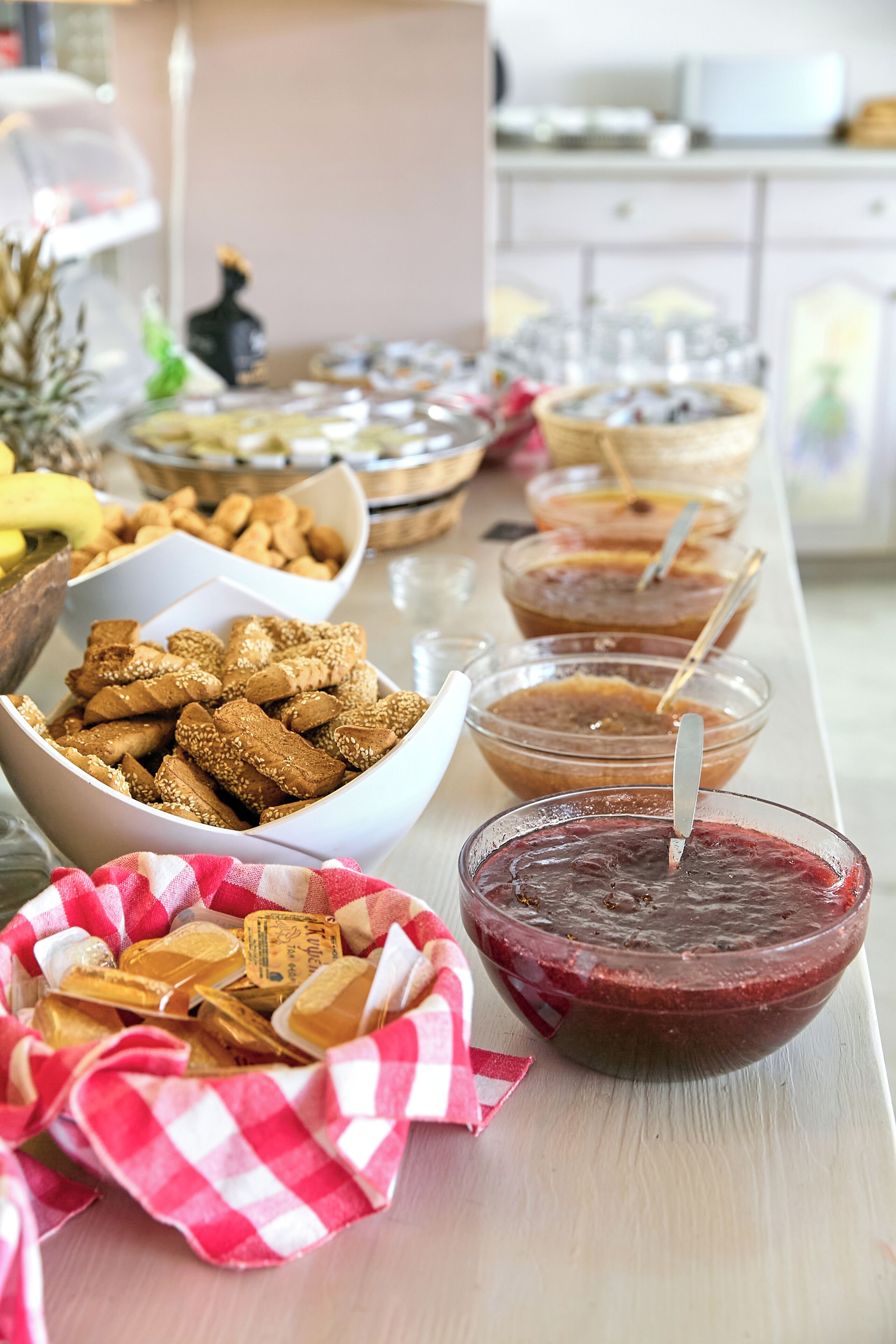 A buffet table with various food items including bowls of cookies, dips, and a basket of pastries.