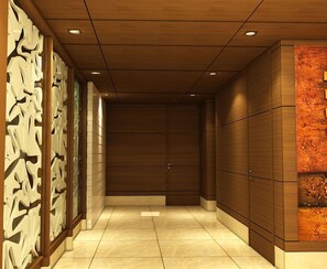 A hallway with wooden paneling, a tiled floor, and a decorative wall on the right. - Hotel Swati (New Delhi)