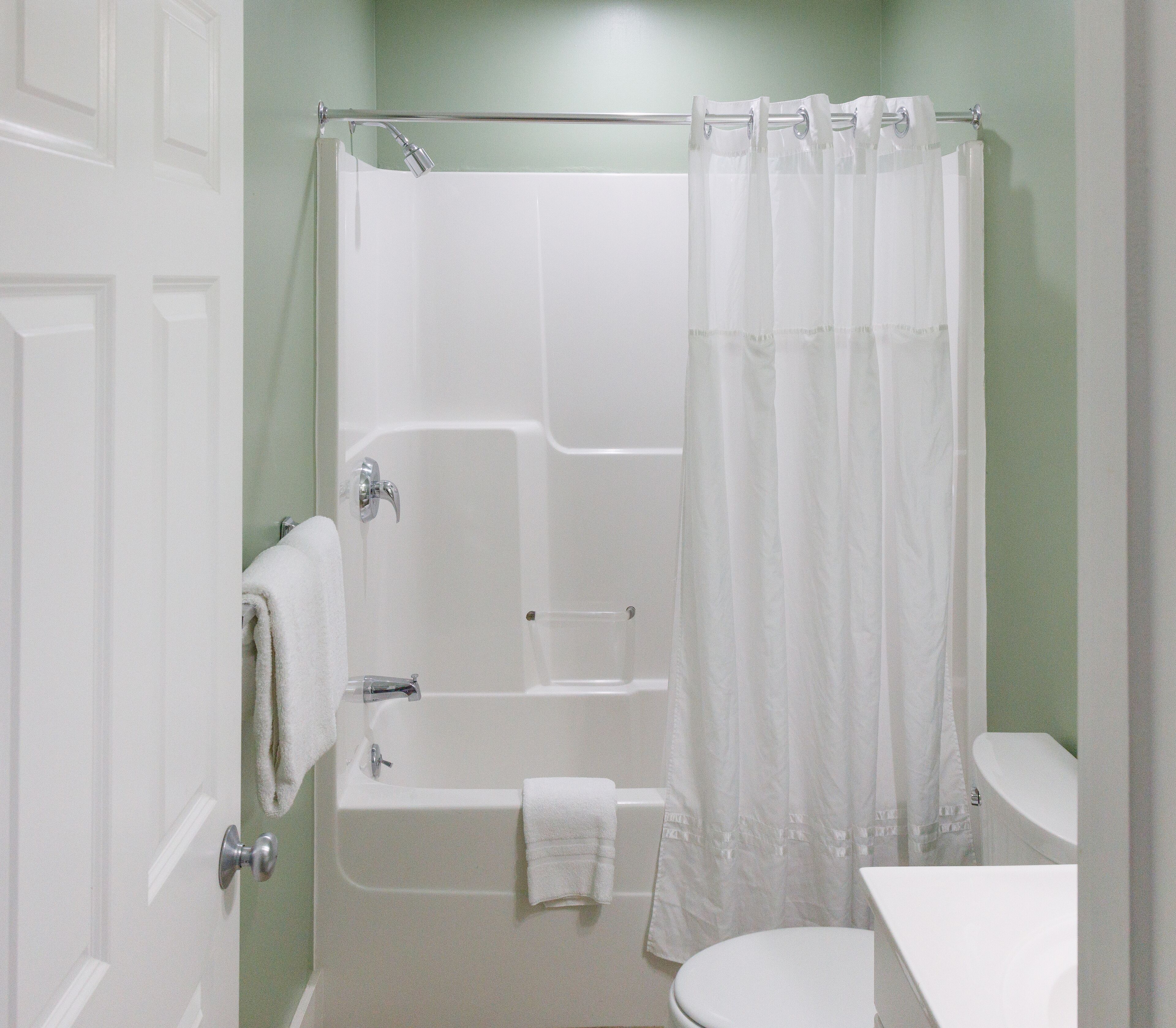 Un baño con bañera, inodoro y cortina de ducha.