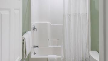 Un baño con bañera, inodoro y cortina de ducha.