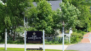 A sign for The Admiral's Inn with a message board and a flower bed. - The Admiral's Inn Resort (Ogunquit)