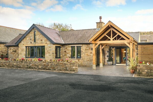 A stone building with a wooden porch and a stone wall with flowers.