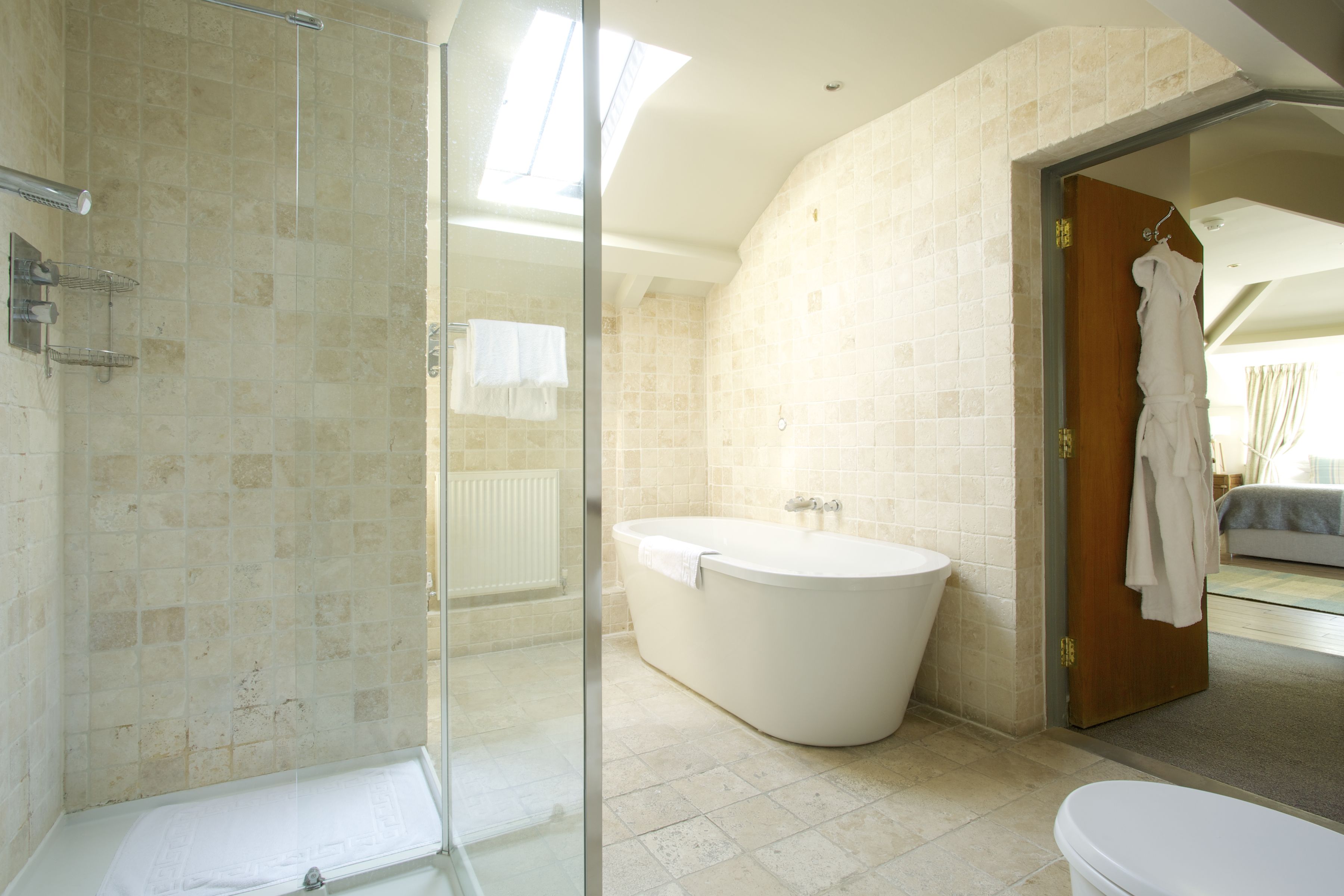 Une salle de bain moderne avec une douche à parois de verre, une baignoire sur pieds et des toilettes.
