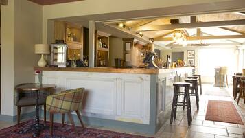 A kitchen with a bar area, wooden cabinets, and a patterned rug.