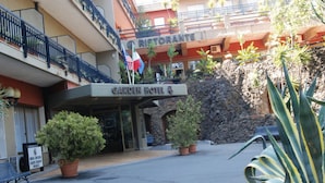 A hotel entrance with a sign for 'Garden Hotel' and a 'Ristorante' above. There are potted plants and a stone wall in front. - Garden Hotel (San Giovanni la Punta)