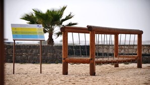 A wooden swing set with a sign in the background.