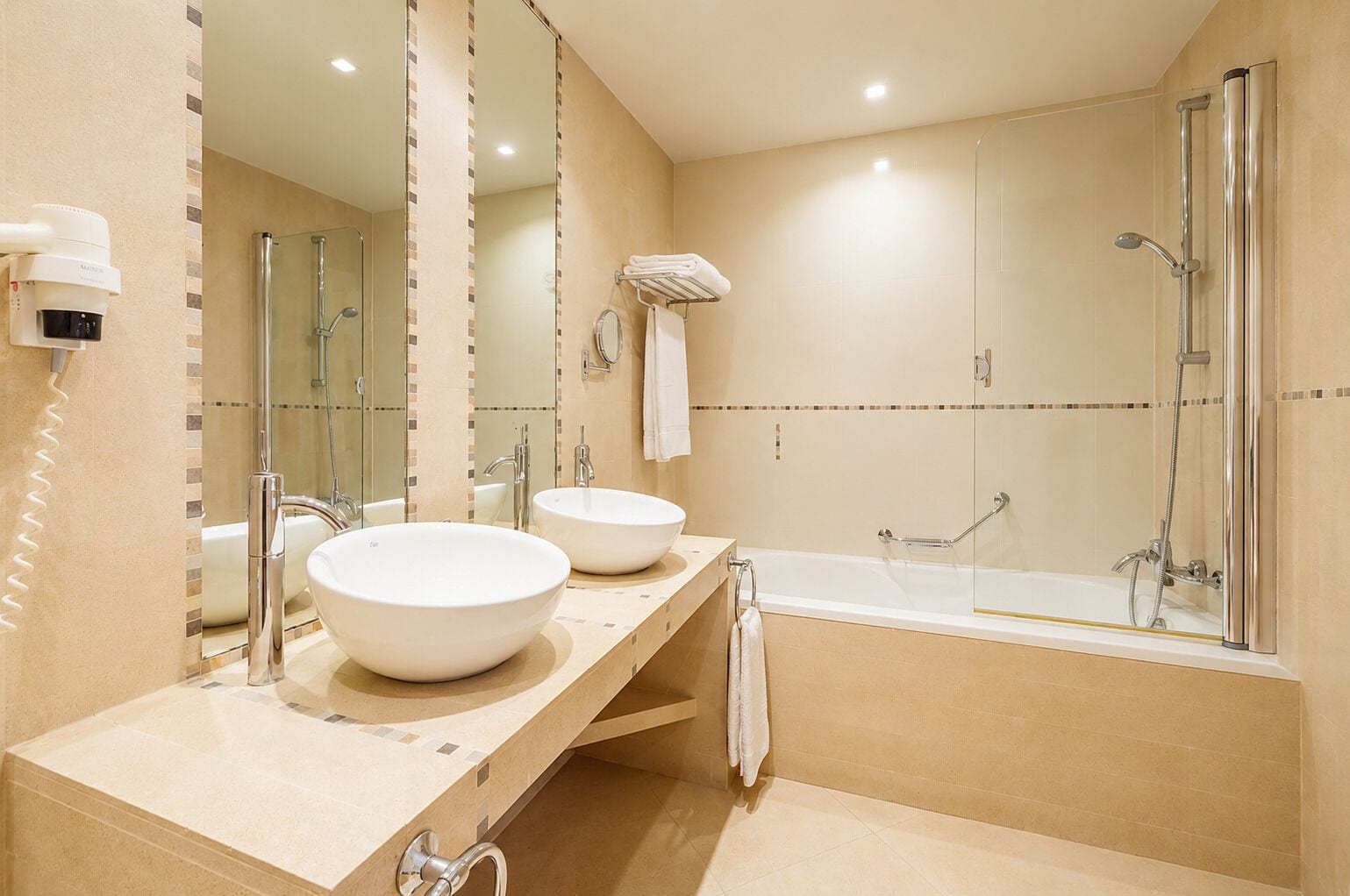 Un bagno moderno con due lavandini, una vasca e una doccia.