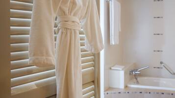Une salle de bain avec une baignoire, un porte-serviettes avec un peignoir, et des toilettes.