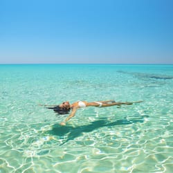 En la playa, playa de arena blanca, camastros y sombrillas