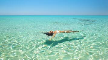 Sulla spiaggia, sabbia bianca, lettini da mare, ombrelloni