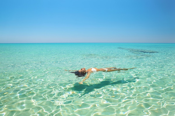 En la playa, arena blanca, sillas reclinables de playa, sombrillas