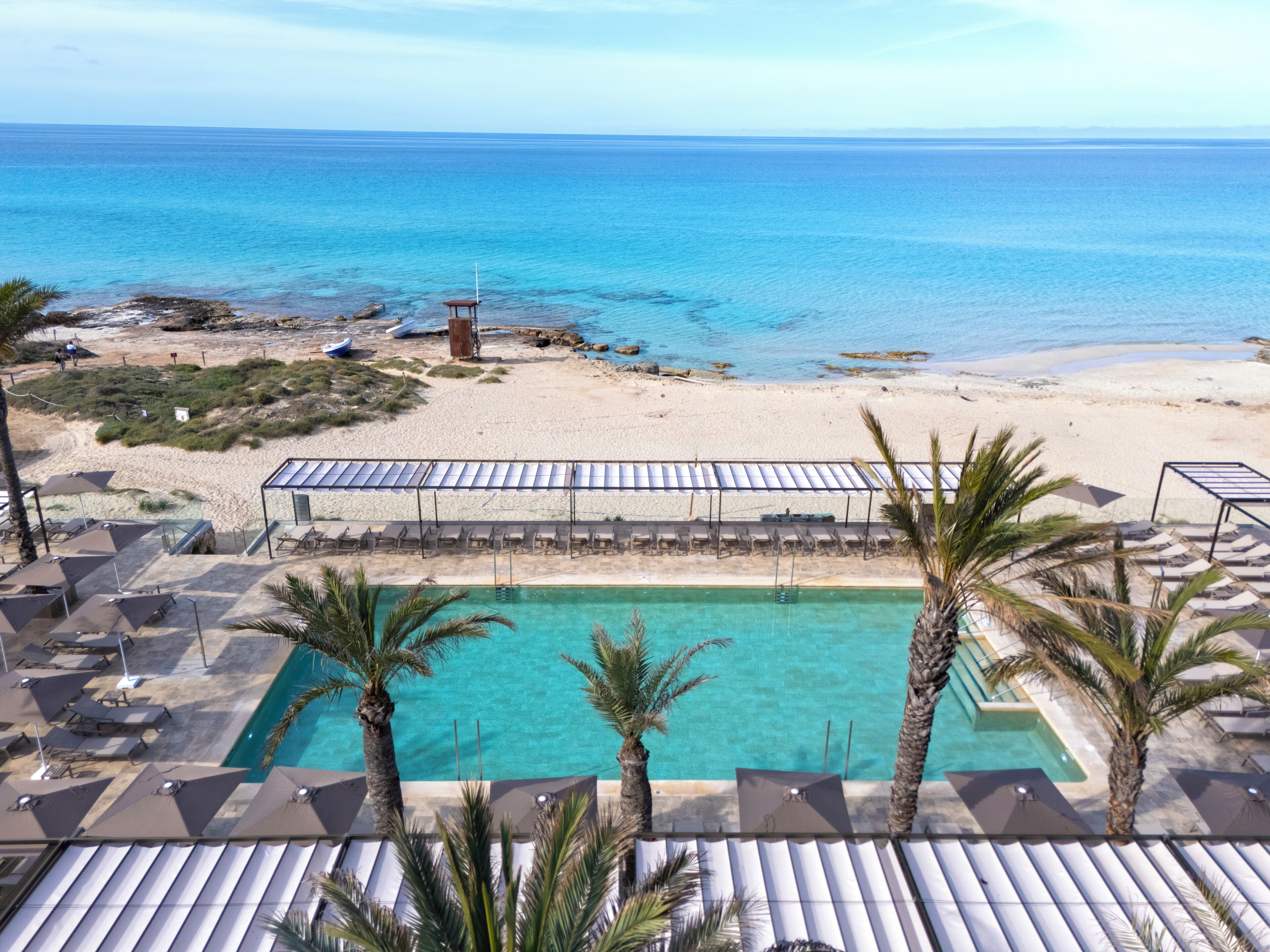 Un resort con piscina, playa y vista al océano.